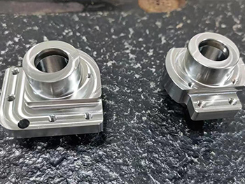 Machined housings with square flanges and circular bores